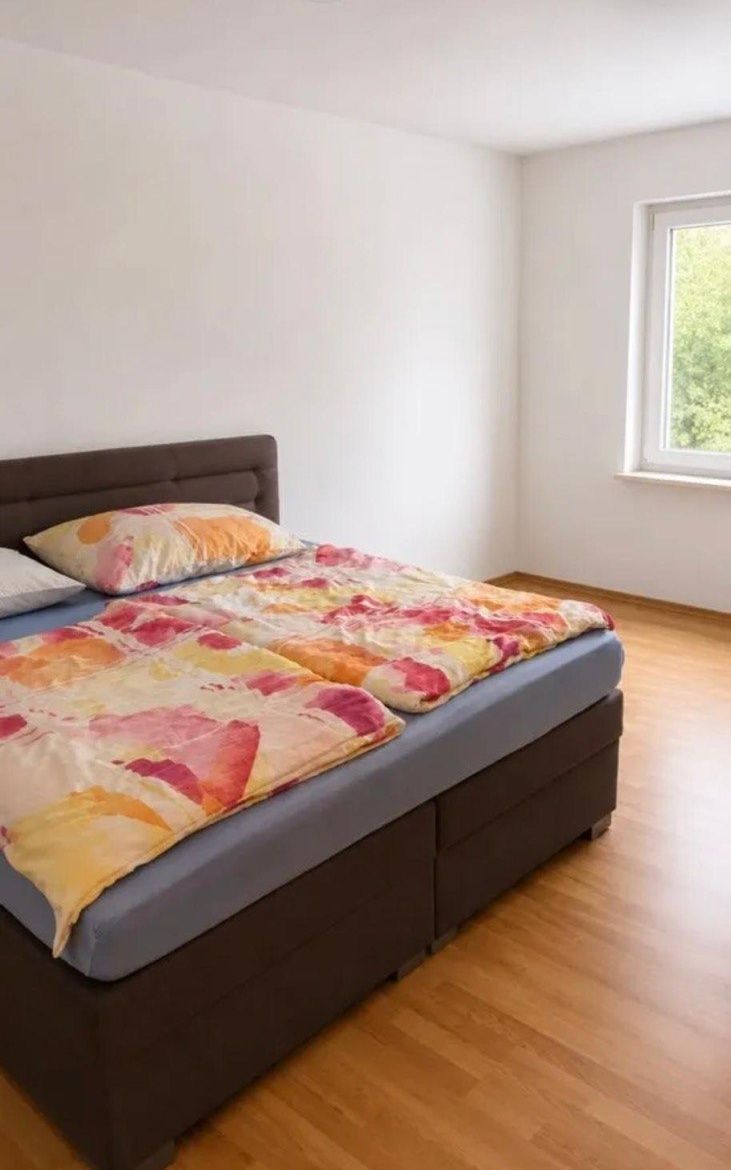 Schlafzimmer mit Doppelbett in der Mitarbeiterwohnung in Steyr